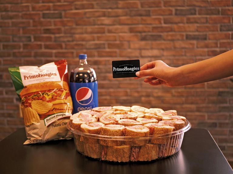 Primo Gift Card over catering tray, chips, drink